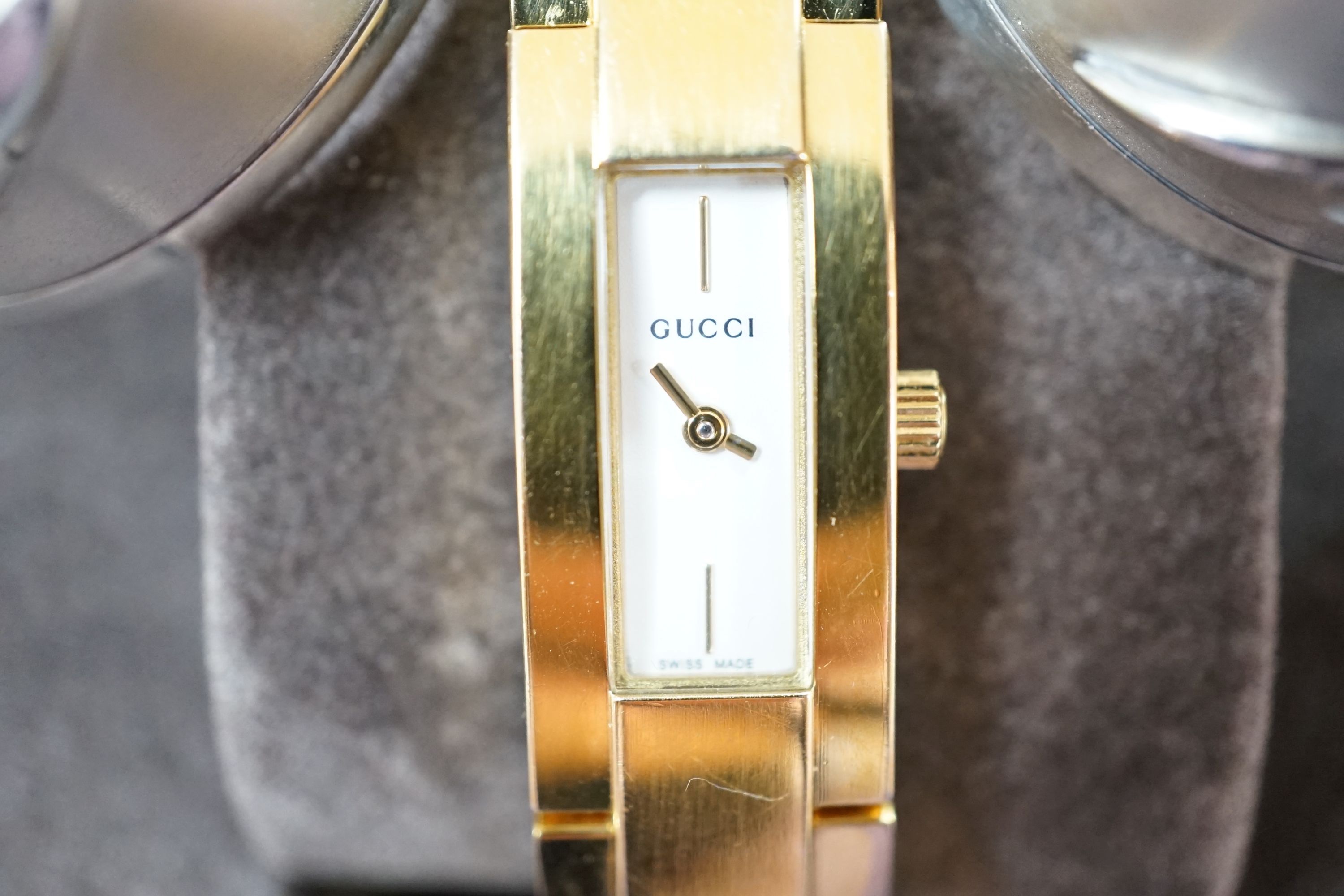 A modern pair of silver 'Concorde' napkin rings, together with a lady's gilded stainless steel Gucci quartz wrist watch with box, no papers.